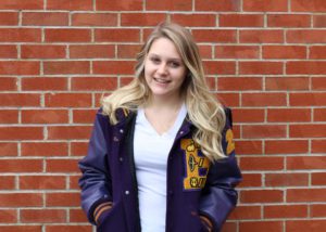 Catie Roberts-Nault in front of brick wall