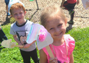 Childcare students in playground with horse crafts