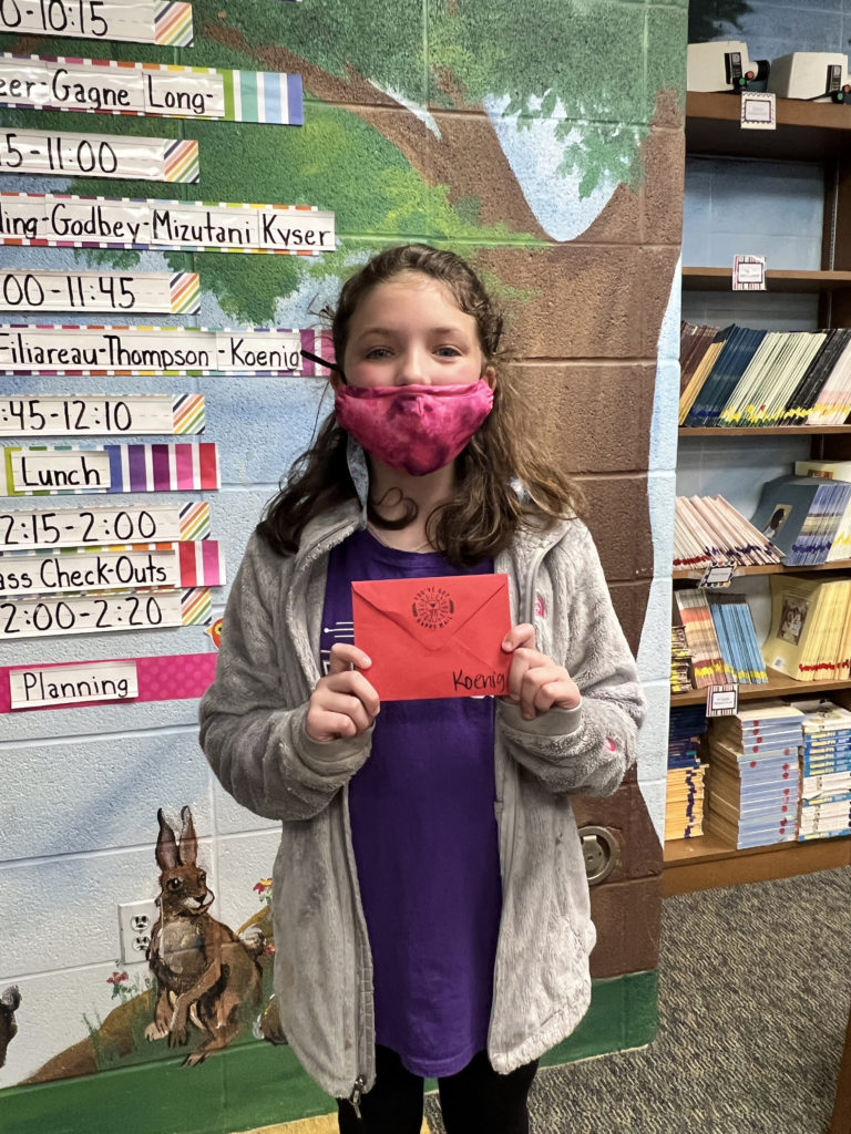 A student in Mrs. Koenig's class holds her letter.