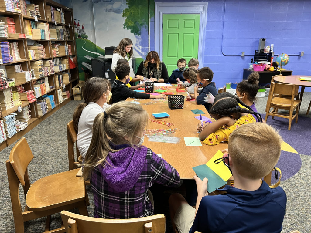 School psychologist Megan Andrew meets with students in the media center to help them write their letter and pick out a friendship bracelet.