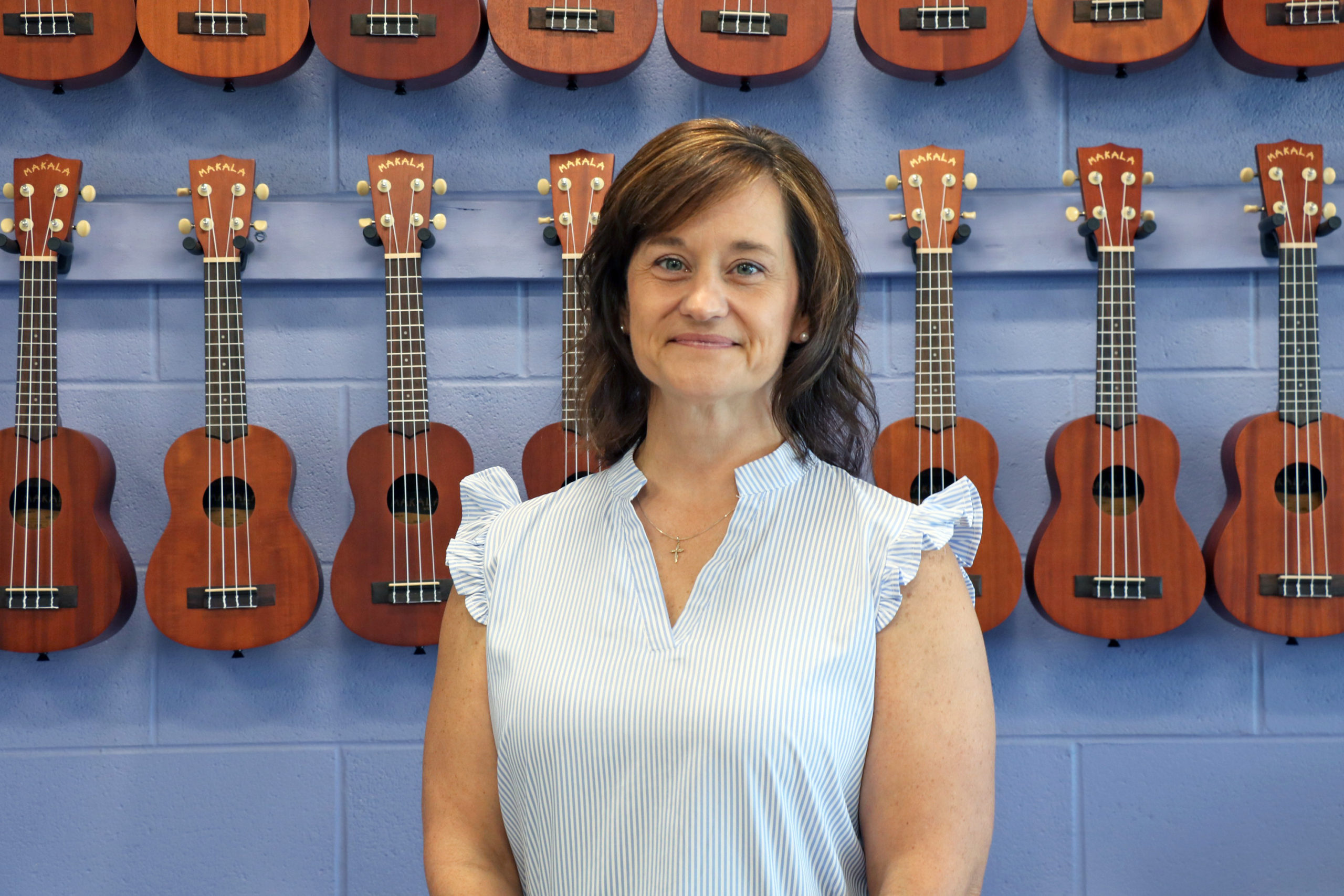 Mrs. Yvette Martin stands in front of her ukuleles