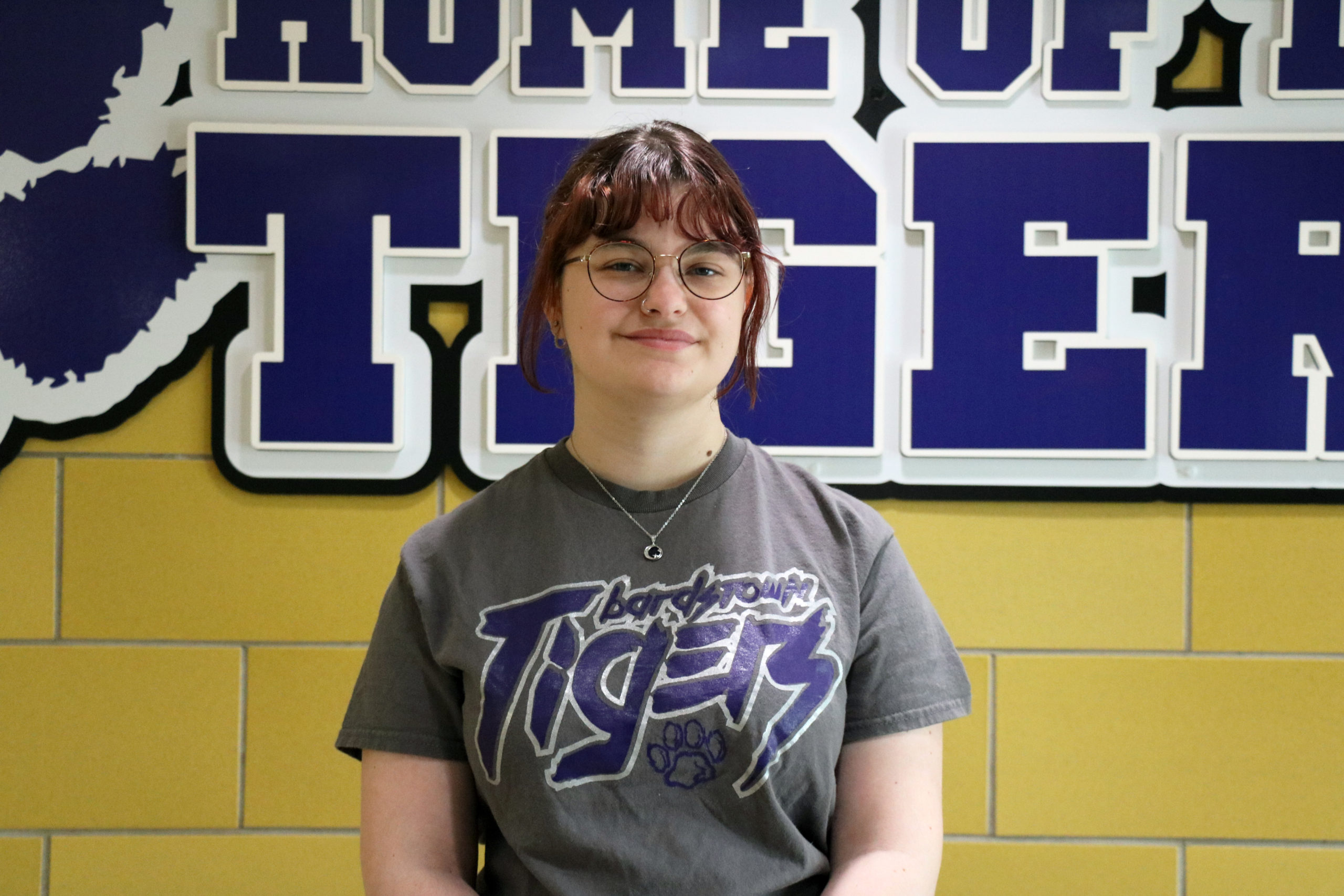 Isabel Harris stands in front of tigers sign