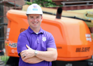 Kirk Brown wearing a hard hat stands in front of the new Bardstown Polytechnic Center.
