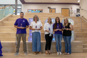 Five employees being photographed with tiger awards