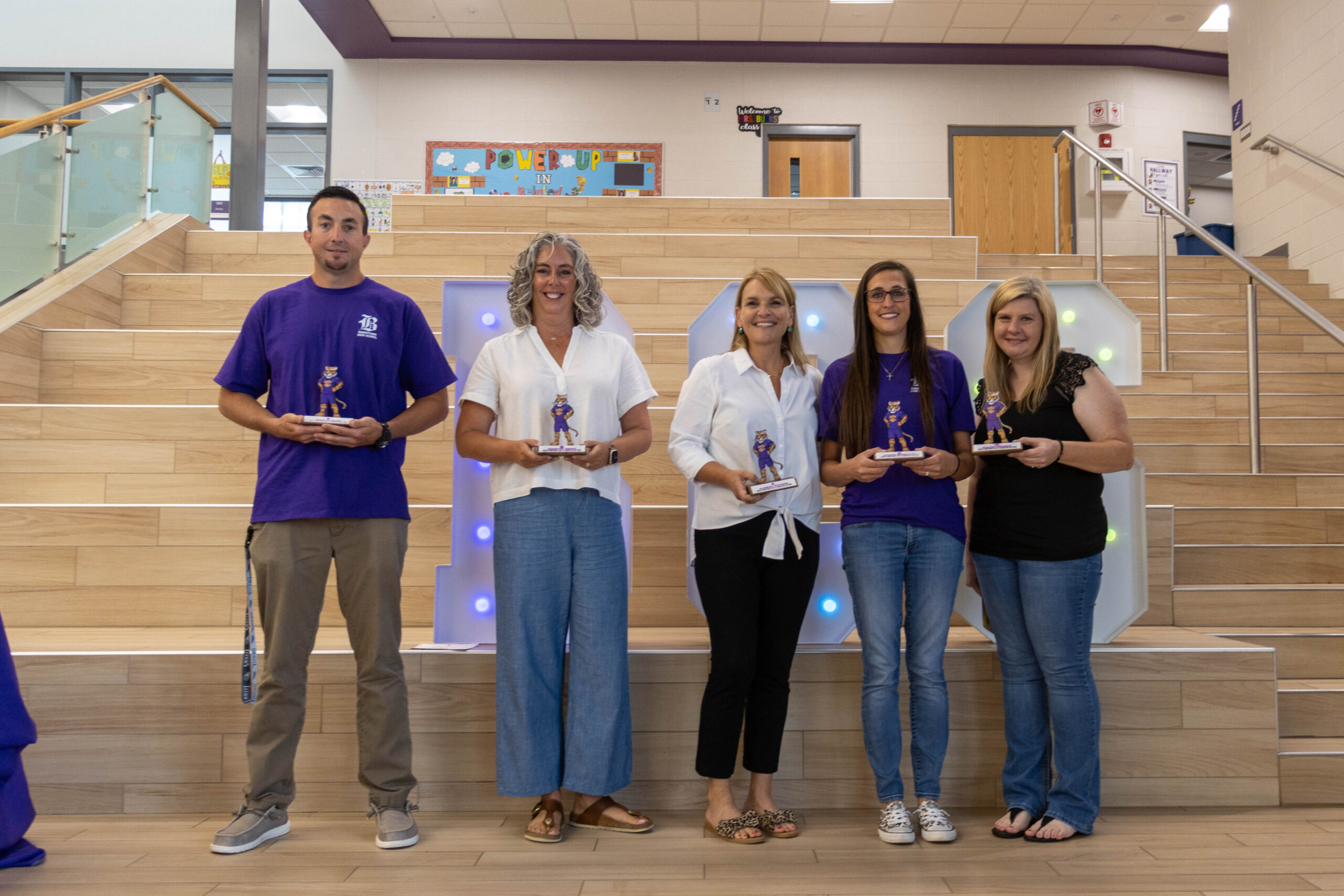 Five employees being photographed with tiger awards