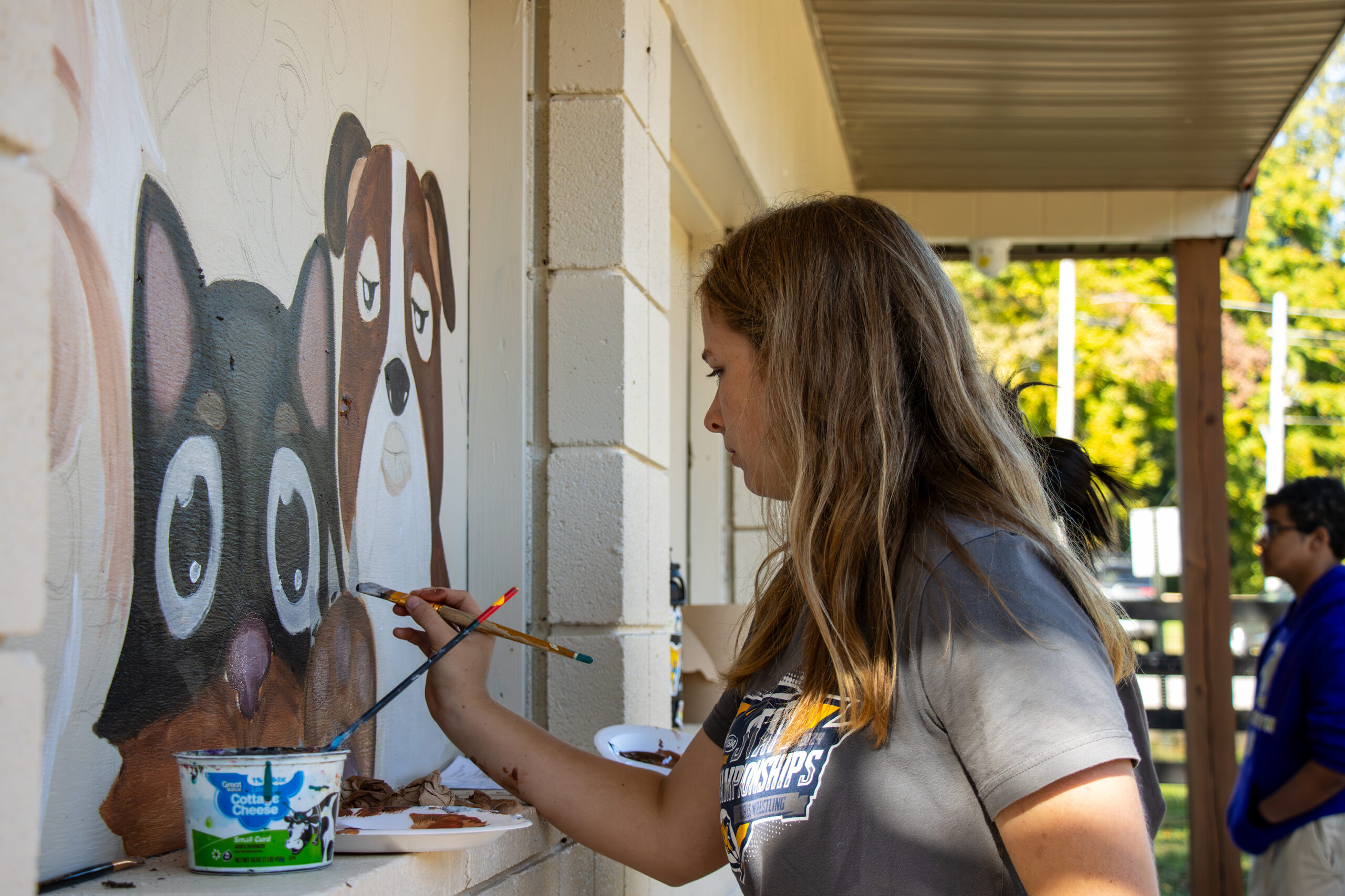 Katy Floyd works on the concession stand mural.