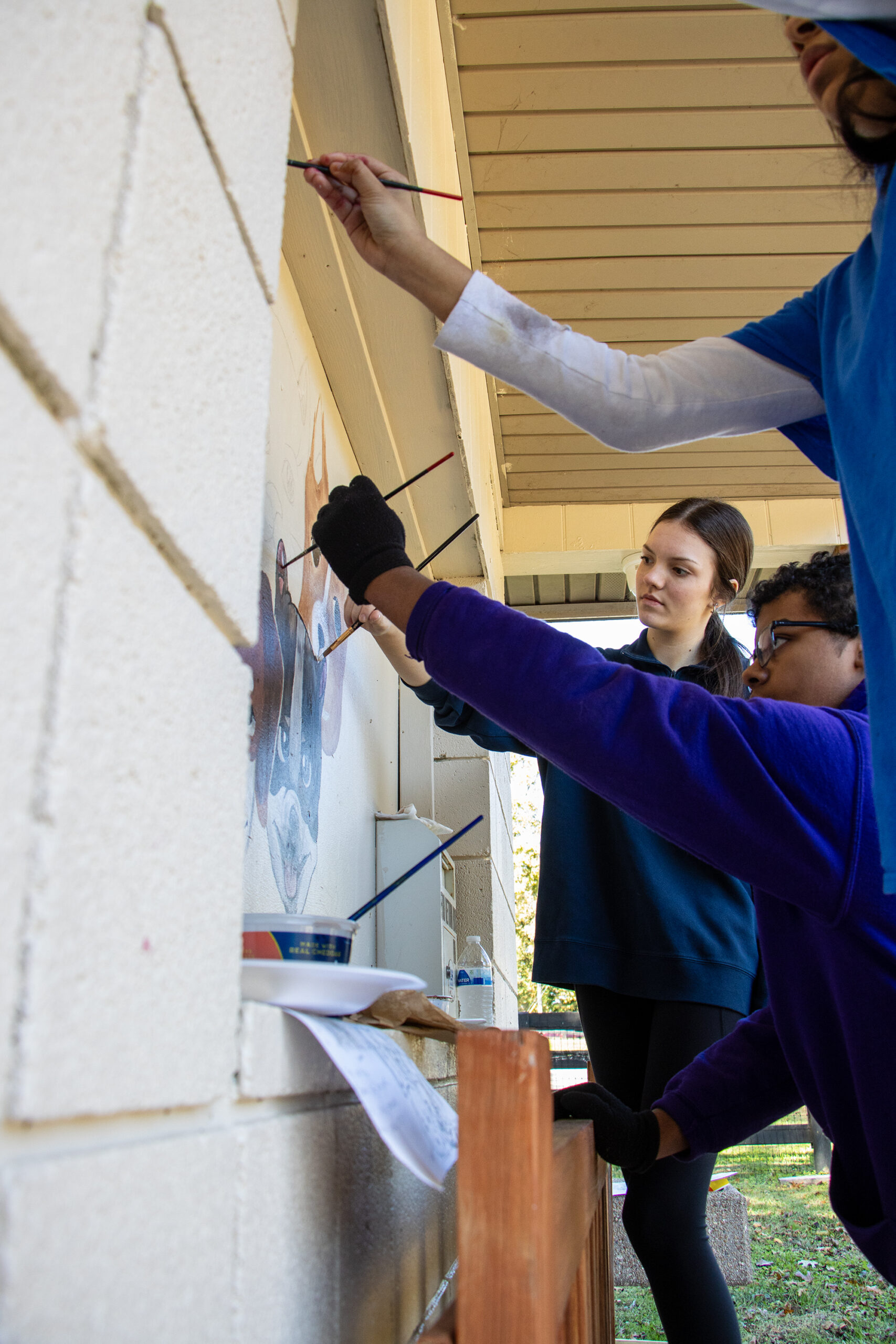 Zeek Mattingly, Madison Snellen, and Daniela Sanchez Hernandez work on the mural.