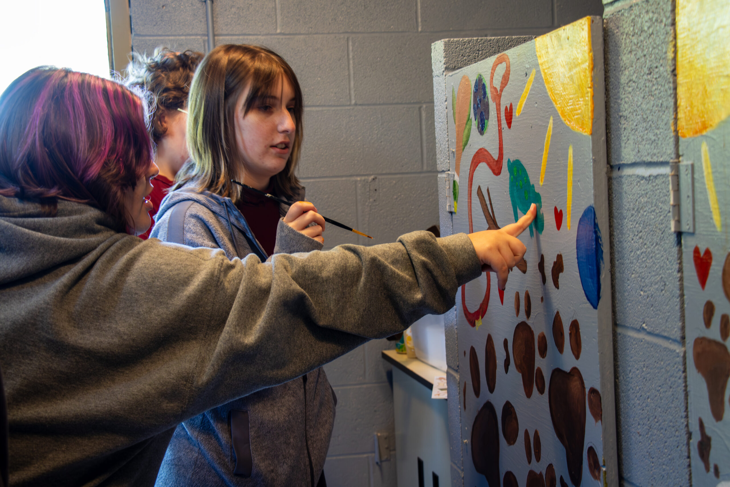 Emma Walls offers Jazmine Kruzich help on detail work.