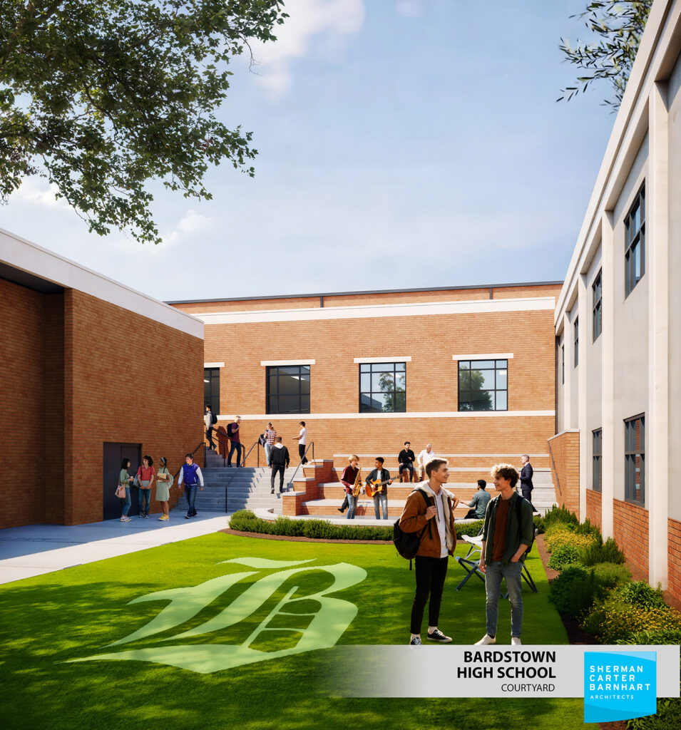 green turf grass between two brick buildings. A gray concrete and brick stage is against the building.