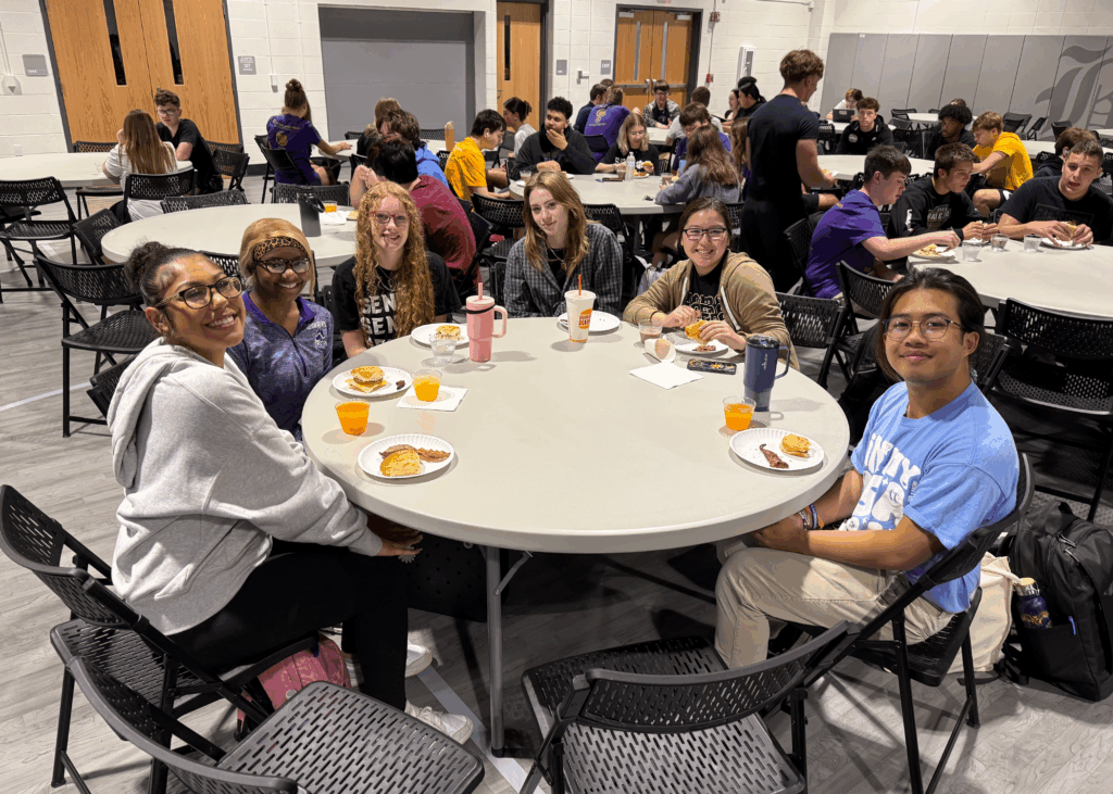 six students having breakfast at a round table