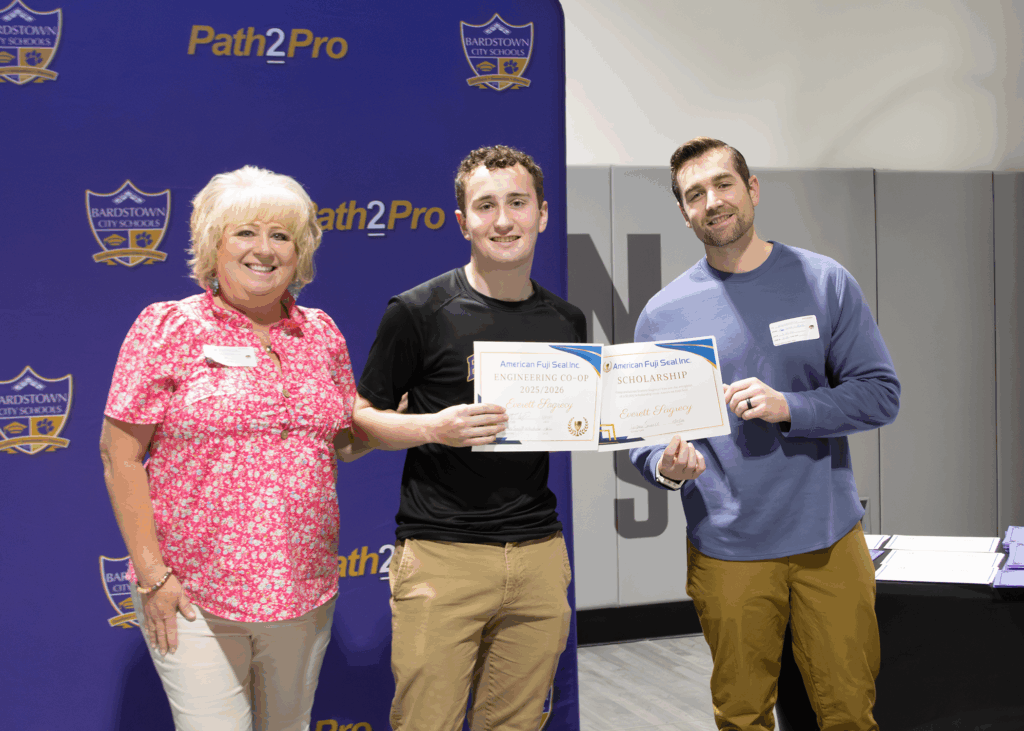 two American Fuji Seal employees presenting BHS student with award